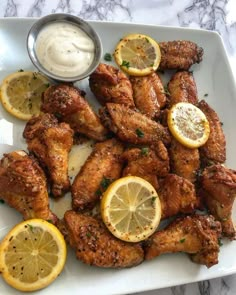 chicken wings with lemons and ranch dressing on a plate