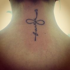 a woman's back neck with a cross and the word faith on her left side