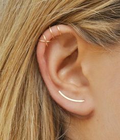 a close up of a person's ear with two small gold hoops on it