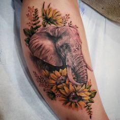 an elephant with sunflowers and leaves on his leg is shown in this tattoo design