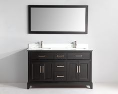 a bathroom vanity with two sinks and a mirror on the wall above it, in front of a white wall