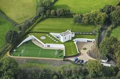 an aerial view of a large house with a soccer field in the middle of it