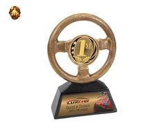 a gold steering wheel trophy with an american flag on it