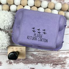 a purple bag sitting on top of a wooden table next to some white and brown balls