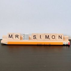 a wooden scrabble with the word mr and mrs on it next to a pencil