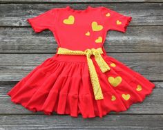 Valentines Day Twirl Dress This cute custom boutique girls Valentines Day dress would be perfect for your baby girl to wear on Valentines Day or just a fun day out in the sun. This dress is red knit with a gold sash and hearts all over. Your baby girl is guaranteed tons of compliments this Valentines Day in this cute little dress. Perfect birthday parties, pageants, or dance wear. Valentines Day Theme 100% Cotton Wash Warm tumble dry low iron if needed Made To Order MADE IN USA Red Gold Dress, Dress Valentines Day, Red And Gold Dress, Valentines Day Dress, Bug Clothing, Pageant Dresses For Teens, Cute Valentines Day Outfits, Hearts Dress, Pageant Wear