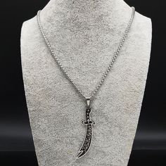 A timeless piece that exudes elegance and masculinity. This intricately designed necklace features a stunning Arabic sword pendant, expertly crafted with intricate details that showcase the rich cultural heritage of the Middle East. The pendant hangs from a durable and stylish chain that complements the sword's unique design. This necklace is perfect for men who appreciate the finer things in life and want to showcase their individuality with a piece that is not only stylish but also rich in his Knife Necklace, Hip Hop Bling, Islamic Jewelry, Imam Ali, Necklace Brands, Stainless Steel Pendant, Steel Necklace, Chains For Men, Stainless Steel Necklace