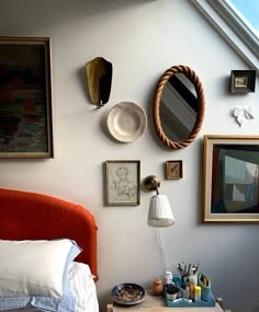 a bed room with a neatly made bed and various pictures on the wall above it