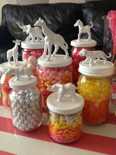 there are many glass jars with candy in them