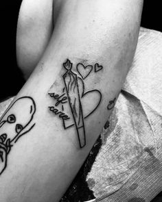 a woman's arm with a tattoo on it and a skull holding a knife