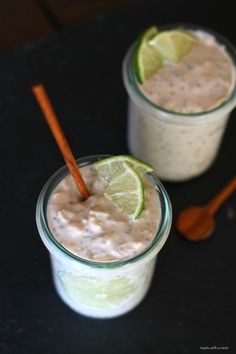 two glasses filled with food and garnished with limes