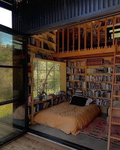 a bed sitting in the middle of a room next to a book shelf filled with books