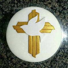 a cake decorated with an image of a dove on it's side and gold strips around the edges