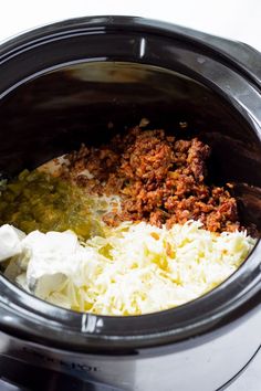 the food in the slow cooker is mixed with cheese and other ingredients to make an entree