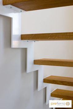 some wooden shelves on the side of a white wall