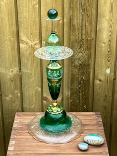 a green vase sitting on top of a wooden table