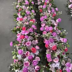 an arrangement of pink and purple flowers on display