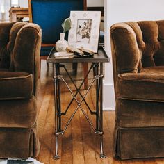 two brown chairs sitting next to each other on top of a hard wood floored floor