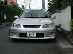 a silver car parked in front of a house