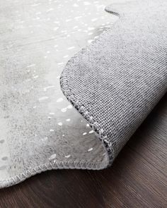 a close up view of a rug on the floor with white dots and gray fabric