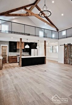 an open floor plan with wood floors and white walls in a large room that has wooden beams on the ceiling