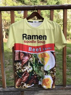 a ramen noodle soup t - shirt hanging on a fence