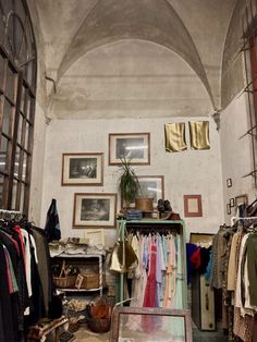 a room filled with clothes and pictures on the wall