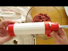 a person is using a red and white blender to make food in a bowl