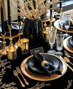 a black and gold table setting with place settings