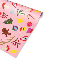 a pink wrapping paper with christmas decorations and candy canes on it, as well as an ornament