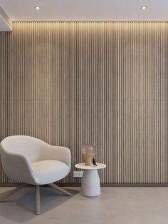 a white chair sitting next to a table in front of a wall with vertical blinds