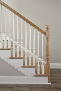 a white staircase with wooden balconies and handrails