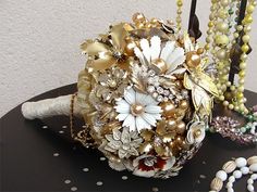 a bridal bouquet sitting on top of a table next to pearls and other beads