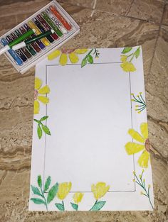 a white paper with yellow flowers on it next to some crayons