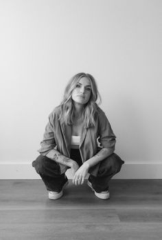 a black and white photo of a woman sitting on the floor