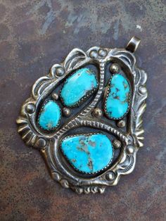 "This is a beautiful pendant made by Zuni master, Horace Iule. It displays an expert casting technique which is what he was well known for. This organic piece features 4 large, natural turquoise cabs set in handmade sawtooth bezels, and wonderful stamping through out. Ca 1950s Dimentions: 2 5/8\" × 2\" Weight: 36g" Handmade Turquoise Medallion Necklace, Collectible Turquoise Jewelry With Patina, Collectible Turquoise Round Pendant Necklace, Antique Turquoise Jewelry With Patina, Collectible Blue Turquoise Necklace With Large Pendant, Collectible Turquoise Necklace With Round Pendant, Antique Untreated Turquoise Jewelry, Handmade Turquoise Necklace Collectible, Artisan Untreated Turquoise Necklace