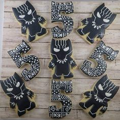 decorated cookies are arranged in the shape of an african man and woman, on a wooden surface