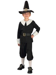 a young boy dressed up in a black and white costume with a hat on his head