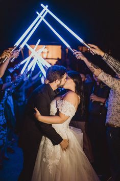 a bride and groom kissing on the dance floor with their arms in the air as they are surrounded by sparklers