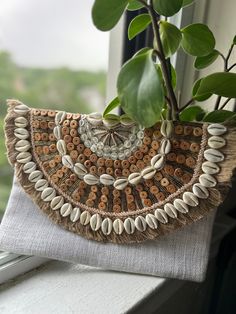 Make a statement with this handcrafted boho clutch, adorned with beautiful shells and intricate beadwork. This unique piece is perfect for those who love to style and experiment with their fashion. Its natural tones and detailed design reflect the true essence of bohemian artistry, making it an ideal accessory for any occasion. Enjoy your shopping and stay glamorous! ✨ Bohemian Clutch, Beautiful Shells, Boho Clutch, Statement Bag, Detailed Design, Shell Beads, Natural Tones, Clutch Handbag, New Bag