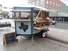 a food cart on the side of the road with a sign in front of it