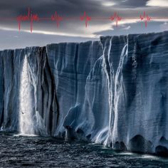 an iceberg in the middle of the ocean with waves coming up from it's sides