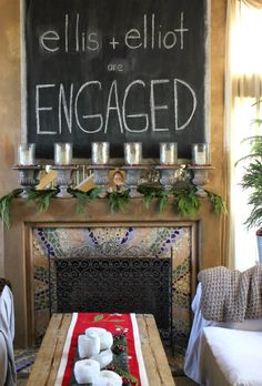 a living room filled with furniture and a chalkboard on the wall above it's fireplace