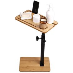 a wooden tray with two bottles and soaps on it, sitting on a stand