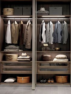 an open closet with clothes hanging on the shelves and other items in front of it