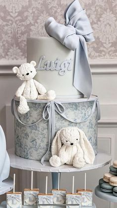 a baby shower cake with teddy bears and cookies on the table next to each other