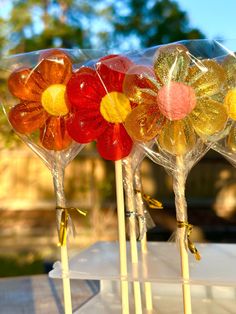 four lollipops with different colored candies on them sitting on a table