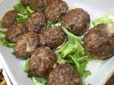 some meatballs and lettuce on a white plate