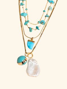 Picture a sunny day by the beach, where the gentle salty breeze and warmth of the sun kisses your skin. This turquoise and gold necklace stack embodies the essence of summer, capturing the vibrant energy and carefree spirit of the season. The Stack Includes: #1 Top Necklace - The Turquoise Dot Choker It is 14 inches. The warm, golden tones of the chains complement the cool hues of the turquoise, creating a striking contrast that embodies the playful elegance of summer. #2 Middle Necklace - The T Ocean-inspired Turquoise Necklaces For Vacation, Turquoise Ocean-inspired Necklaces For Vacation, Turquoise Ocean-inspired Necklace For Vacation, Bohemian Turquoise Necklaces For Layering, Turquoise Multi-strand Necklace For Beach, Turquoise Multi-strand Necklaces For The Beach, Turquoise Bohemian Necklace For Vacation, Gold Natural Stones Jewelry For Vacation, Gold Jewelry With Natural Stones For Vacation