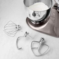 a mixer and attachments on a white counter top